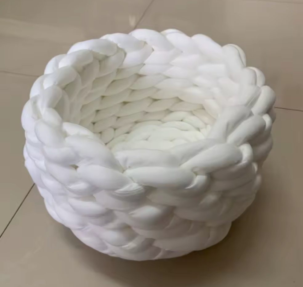 Handgewebtes Katzenbett Grey cat resting in a handmade blue chunky knit cat bed on a light carpet – modern and cozy pet furniture design. Graue Katze liegt entspannt in einem handgewebten, blauen Katzenbett aus dickem Chunky-Strick auf einem hellen Teppich – modernes und gemütliches Design für Haustiere.