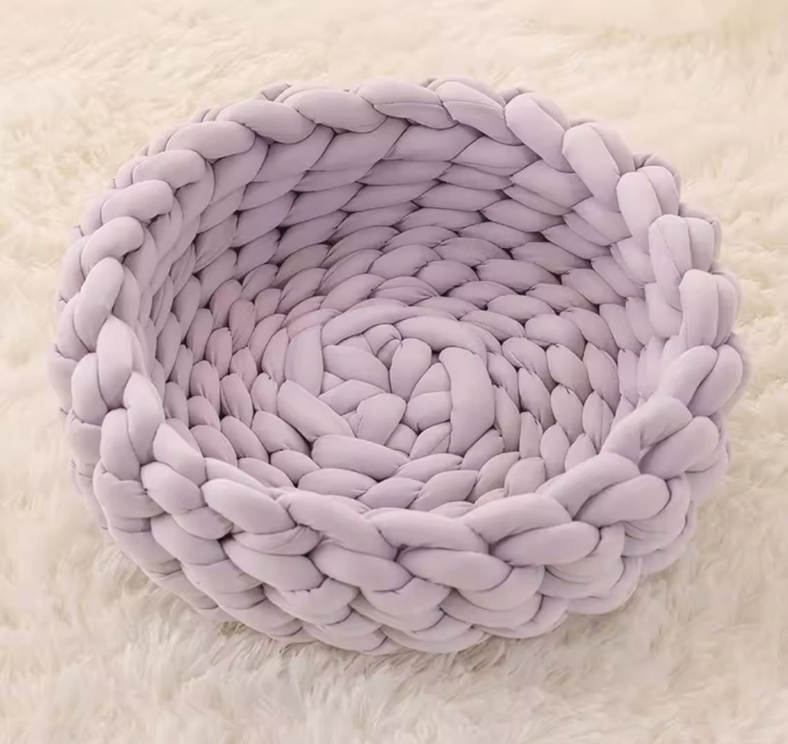 Handgewebtes Katzenbett Grey cat resting in a handmade blue chunky knit cat bed on a light carpet – modern and cozy pet furniture design. Graue Katze liegt entspannt in einem handgewebten, blauen Katzenbett aus dickem Chunky-Strick auf einem hellen Teppich – modernes und gemütliches Design für Haustiere.